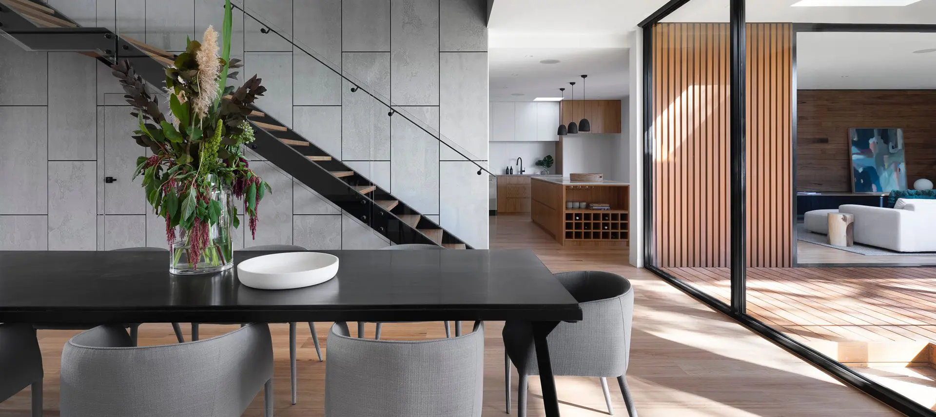 A dining room table and chairs in front of stairs.