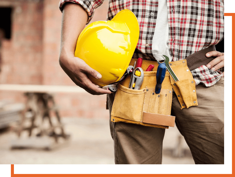 A man holding his hard hat and tool belt.